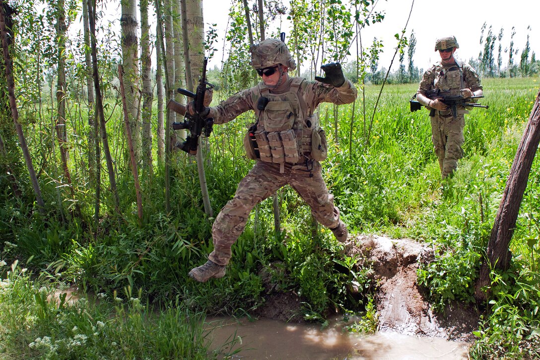 U.S. Army Staff Sgt. Ray Perez-Rosa jumps over a water-filled ditch while on a foot patrol to counteract indirect fire near Combat Outpost Baraki Barak, Logar province, Afghanistan, May 21, 2013. Perez-Rosa, a infantryman, is assigned to the 3rd Infantry Division's 6th Squadron, 8th Cavalry Regiment, 4th Infantry Brigade Combat Team.