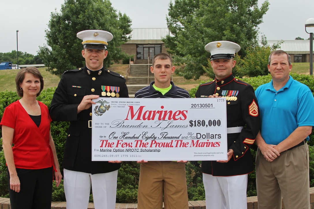Captain Alexander B. Pearson, the executive officer of Marine Corps Recruiting Station Columbia, and Staff Sgt. Michael A. Fallaw, a canvassing recruiter with Recruiting Substation Lexington, present a Naval Reserve Officers Training Corps Scholarship check to Brandon T. James on May 31 at Batesburg-Leesville High School. The NROTC scholarship, valued at up to $180,000, will pay for the cost of full tuition, books and other educational fees at many of the country’s leading colleges and universities. (Marine Corps Photo by Sgt. Aaron Rooks)