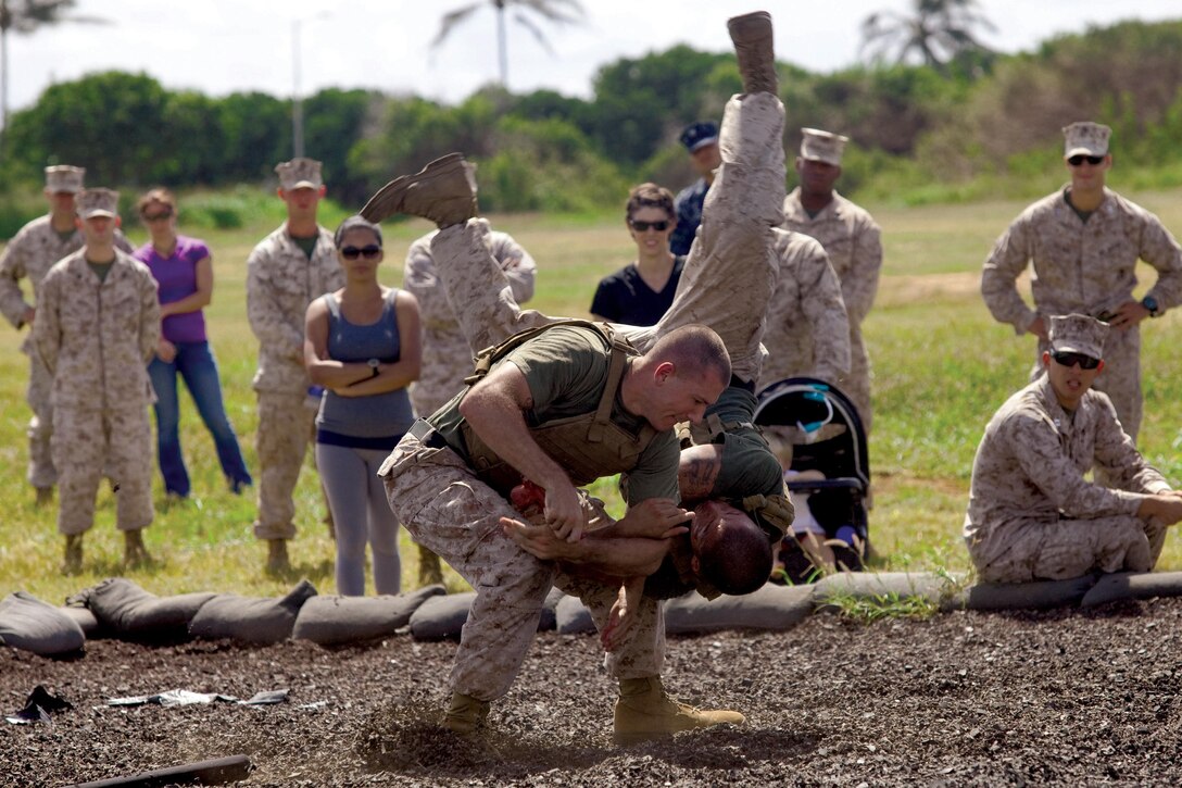 MARINE CORPS BASE HAWAII - Sgt. Skyler Tooker and Cpl. Brian Giera, Marine Corps Martial Arts Program instructors with Headquarters Battalion, demonstrate MCMAP techniques during the unit’s first Warrior Day, May 24. The family members were encouraged to try out the techniques themselves after the initial demonstration. (U.S. Marine Corps photo by Lance Cpl. Janelle Y. Chapman) 