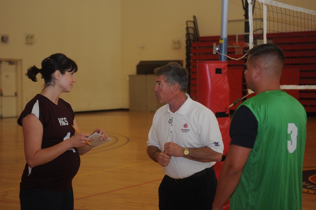 Lauren Fink, captain of the Headquarters and Service Bn. volleyball team and Sgt. William Quinn, captain of the Marine Helicopter Squadron volleyball team discuss the game with the referee at Barber Physical Activities Center aboard Marine Corps Base Quantico on May 13, 2013. The teams faced off for the first game of the intramural season.