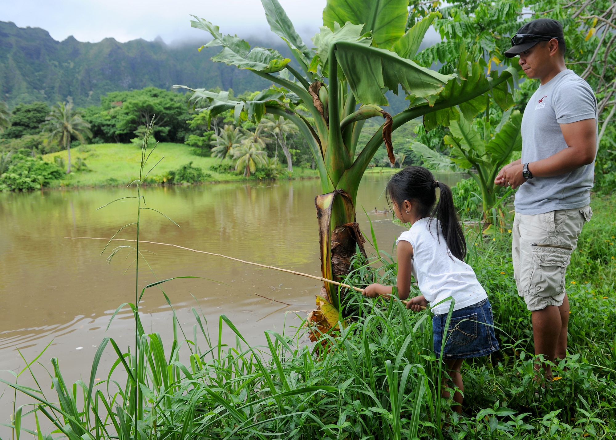 Amara Dancel, 6,  and her father Senior Airman Aaron Dancel, 747th Communication Squadron, cyber transportation technician, works as a team during the Keiki Fishing Tournament, hosted by Friends of Hickam, at the Ho`omaluhia Botanical Gardens, in Kaneohe, Hawaii, May 29, 2013. This is the 14th straight year the Friends of Hickam has hosted the event for more than 100 children every year. (U.S. Air Force photo/Tech. Sgt.  Jerome S. Tayborn)