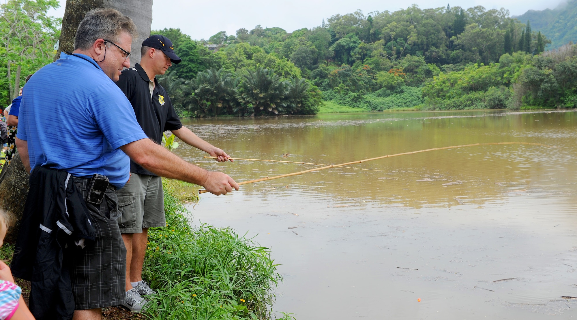 Bruce Shewalter, Friends of Hickam President, left, engages in a "fish-off" against Col. Dan Baldessari, 15th Operations Group commander, right, to kick off the beginning of the 2013 Keiki Fishing Tournament at Ho'omaluhia Botanical Gardens in Kaneohe, Hawaii, May 29, 2013. The fishing tournament was sponsored by the Friends of Hickam, a group of community leaders who facilitate between the 15th Wing at Joint Base Pearl Harbor-Hickam, Hawaii, and the Hawaii community seeking to support, promote, and foster stronger community relations with those associated with the 15th Wing. (U.S. Air Force photo Tech. Sgt.  Jerome S. Tayborn)