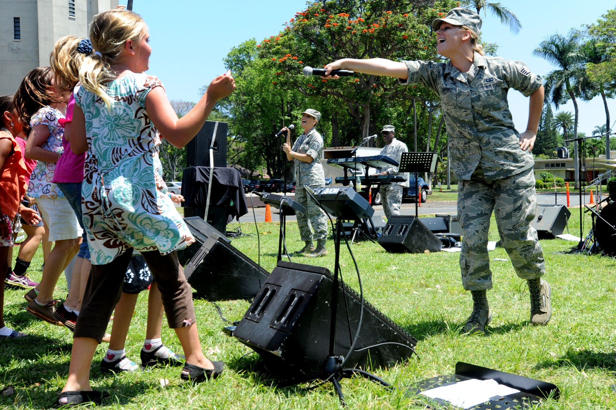 JOINT BASE PEARL HARBOR-HICKAM, Hawaii -- Staff Sgt. Courtney Clifford, a vocalist with the United States Band of the Pacific - Hawaii Hana Hou! Ensemble here, points her microphone at a group of girls in the audience so they can sing along with the band during a performance at Hickam Elementary School, May 22, 2013.  One of the main goals for the United States Band of the Pacific – Hawaii is to strengthen their relationship with the local community through music.  (U.S. Air Force photo by Dakota Chance)