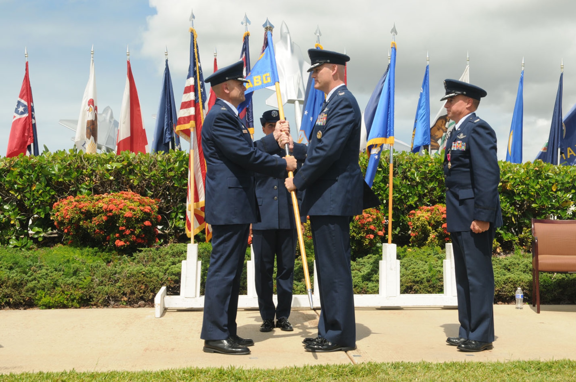 Col. David Kirkendall (center) assumes command of the 647th Air Base Group, Joint Base Pearl Harbor-Hickam, Hawaii on 31 May 2013 at the Missing Man Formation on Hickam Field. Col. Johnny Roscoe (left), Commander, 15th Wing presents the guidon. Col. Dann Carlson (right) is the departing 647th ABG  commander.  (Photo by David D. Underwood, Jr.)
