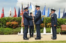 Col. David Kirkendall (center) assumes command of the 647th Air Base Group, Joint Base Pearl Harbor-Hickam, Hawaii on 31 May 2013 at the Missing Man Formation on Hickam Field. Col. Johnny Roscoe (left), Commander, 15th Wing presents the guidon. Col. Dann Carlson (right) is the departing 647th ABG  commander.  (Photo by David D. Underwood, Jr.)