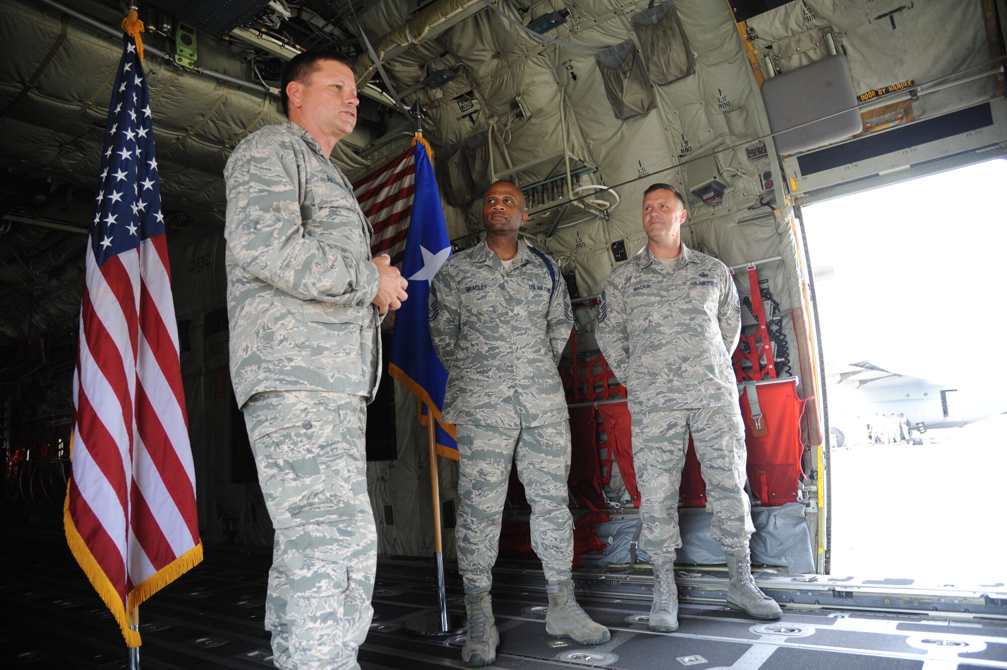 Maj. Gen. Leonard Patrick, 2nd Air Force commander, prepares to reenlist Chief Master Sgts. Edward Bradley III, 2nd AF military training career field manager, and Deno Mackin, 2nd AF command chief, during a reenlistment ceremony May 31, 2013,inside a C-130J aircraft at Keesler Air Force Base, Miss.  Together they have dedicated over 56 years of military service. Together they’ve dedicated more than 56 years of military service.  (U.S. Air Force photo by Kemberly Groue)