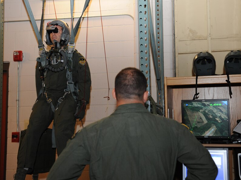 Lt. Col. David Bares, 2nd Operations Support Squadron assistant director of operations, maneuvers a simulated parachute as Tech. Sgt. Mike Slaton, 2nd Operations Support Squadron Survival, Evasion, Resistance and Escape specialist, watches his progress on Barksdale Air Force Base, La., May 31, 2013. The parachute simulator aids aircrew members by being a safe, economical and an accurate representation of an actual egress. (U.S. Air Force photo/Airman 1st Class Benjamin Gonsier)