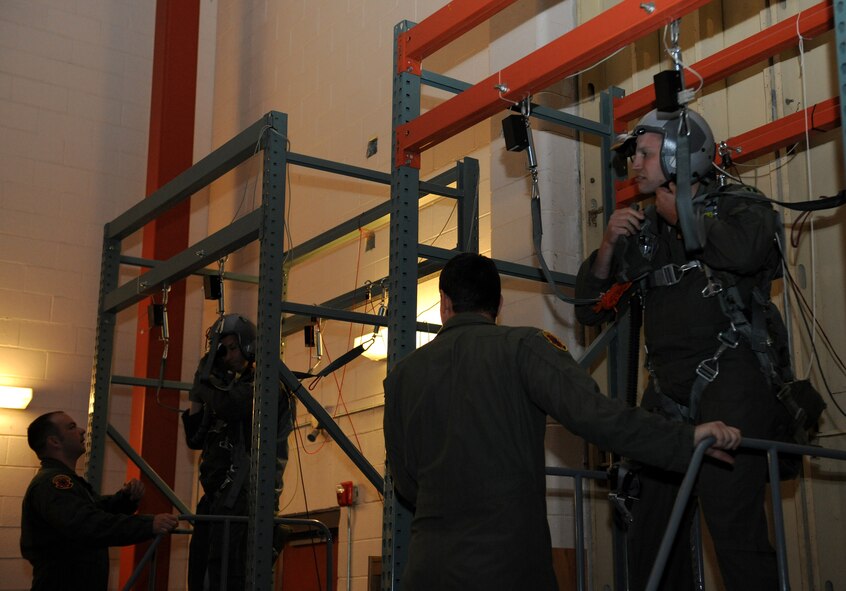 Tech Sgt. Mike Slaton, left, and Staff Sgt. Charles Millison, 2nd Operations Support Squadron Survival, Evasion, Resistance and Escape specialists, secure aircrew personnel to parachute simulators on Barksdale Air Force Base, La., May 31, 2013. The parachute simulator aids aircrew members by being a safe, economical and an accurate representation of an actual egress. (U.S. Air Force photo/Airman 1st Class Benjamin Gonsier)