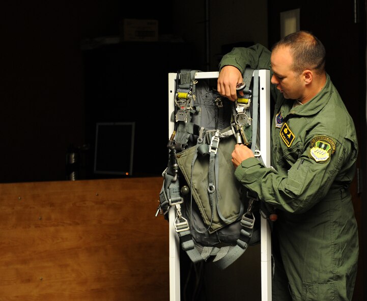 Tech. Sgt. Mike Slaton, 2nd Operations Support Squadron Survival, Evasion, Resistance and Escape specialist, demonstrates the right mechanism to pull during the parachuting process on Barksdale Air Force Base, La., May 31, 2013. Aircrew must undergo annual training on aircraft egress which includes getting out of the aircraft and properly parachuting to safety. (U.S. Air Force photo/Airman 1st Class Benjamin Gonsier)