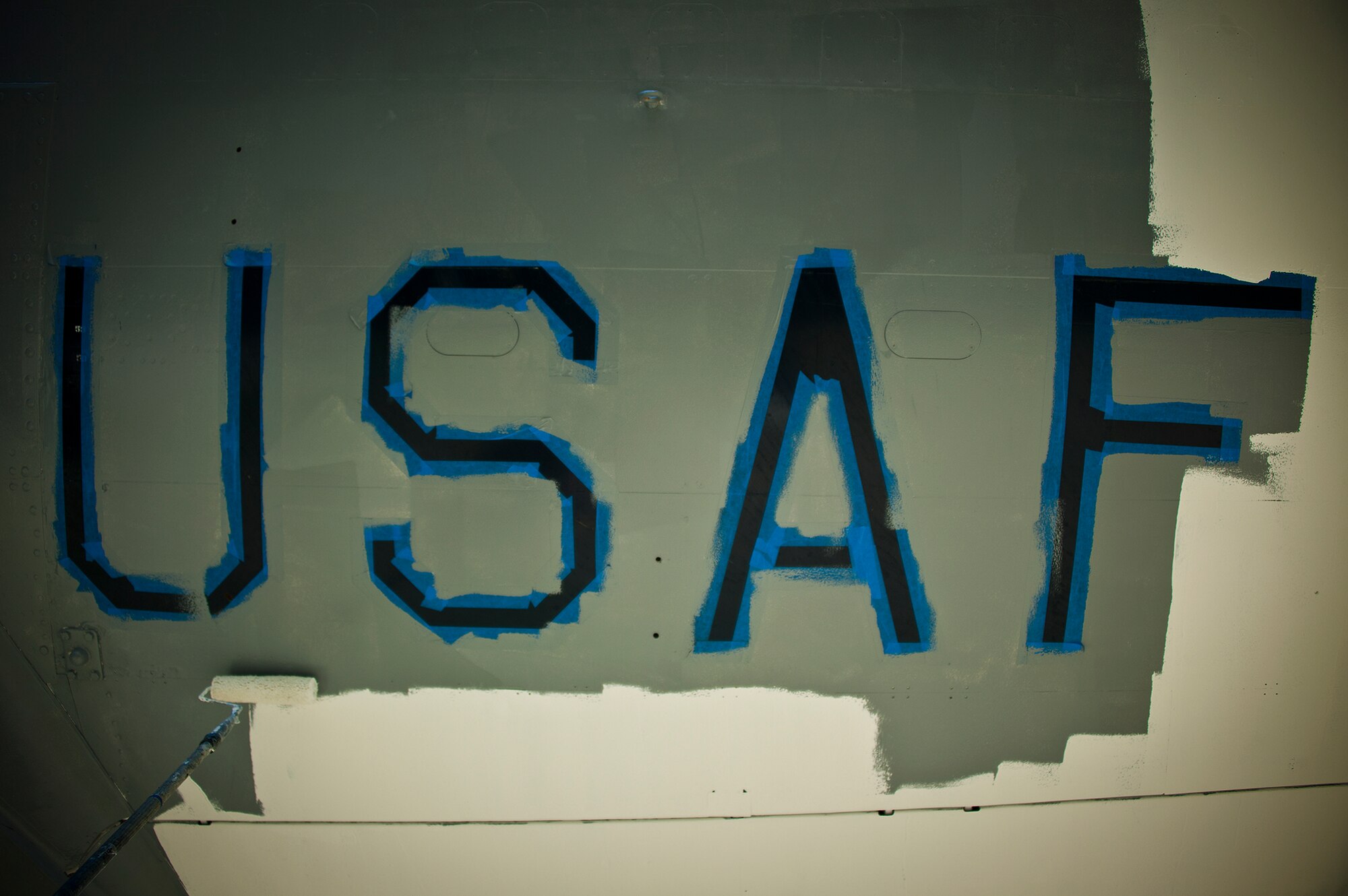 Members of the 96th Logistics Readiness Squadron paint around the USAF insignia on the bottom of the wing of a B-47 aircraft display at the Air Force Armament Museum, May 25.  Members of LRS’s petroleum, oil and lubricants flight work to restore the B-47 as part of Eglin’s Adopt-a-Plane program.  It has been almost 13 years since the B-47 was renovated.  The newly restored aircraft is scheduled to be completed in July. (U.S. Air Force photo/Samuel King Jr.)