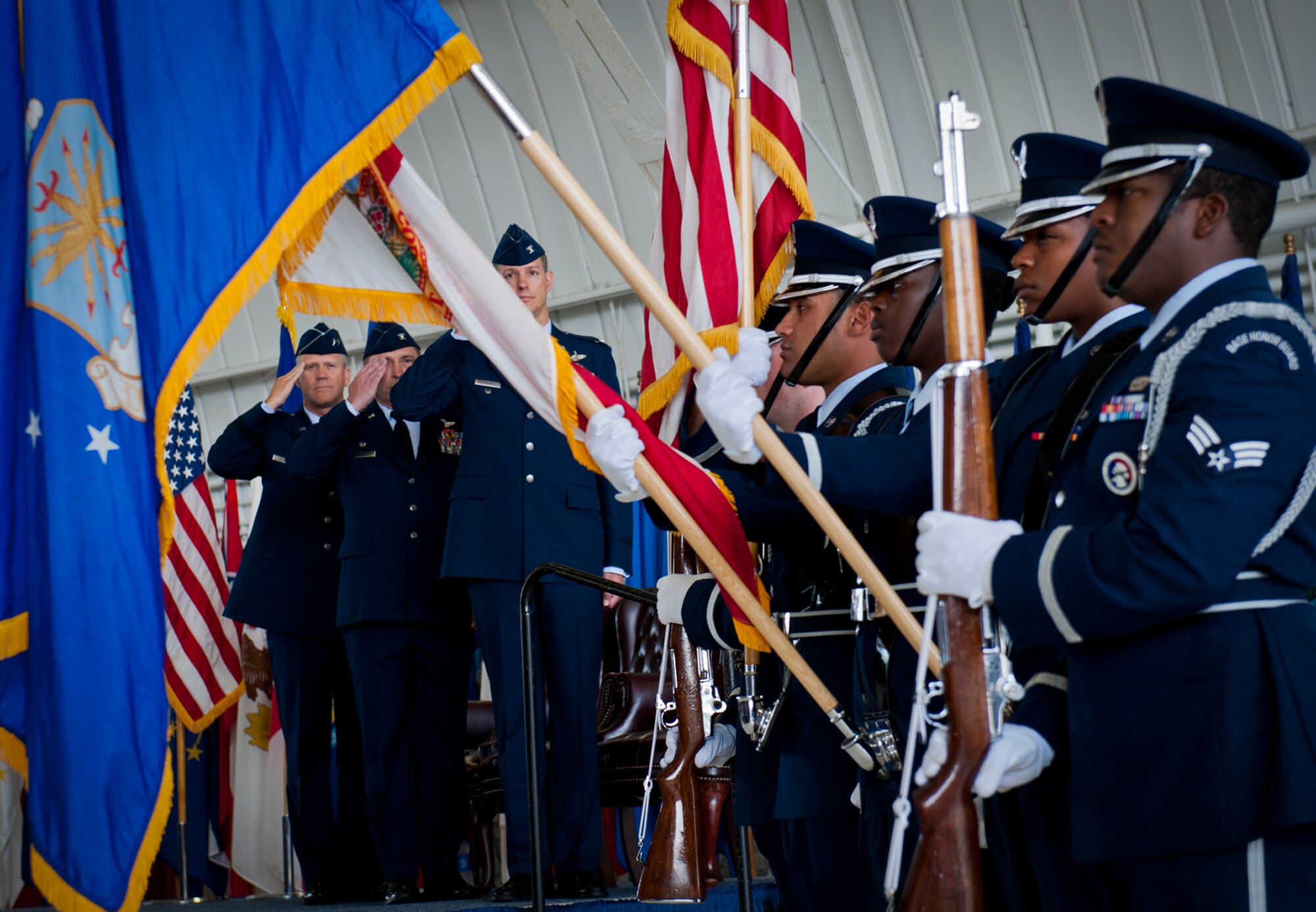 Maj. Gen. Jeffrey Lofgren, the U.S. Air Force Warfare Center commander, Col. David Hicks and the new 53rd Wing Commander, Alexus Grynkewich, salute the flag during the National Anthem at the wing’s change of command ceremony May 30 at Eglin Air Force Base, Fla.  Grynkewich took command of the wing from Hicks, who leaves to become the deputy director of operations for North American Aerospace Defense Command at Peterson, AFB, Colo.  (U.S. Air Force photo/Samuel King Jr.)