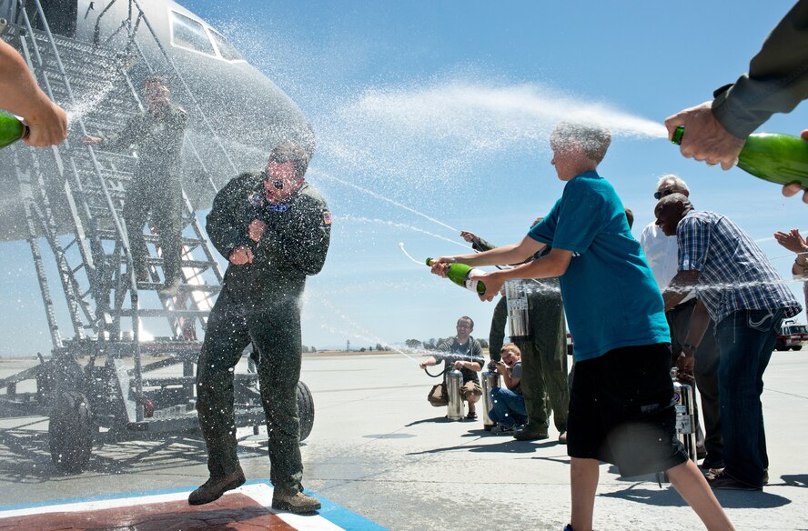 Then 60th Operations Group commander, Col. John Millard, is sprayed down by friends and family following his May 22 "Fini Flight." (Air Force photo/Ken Wright)