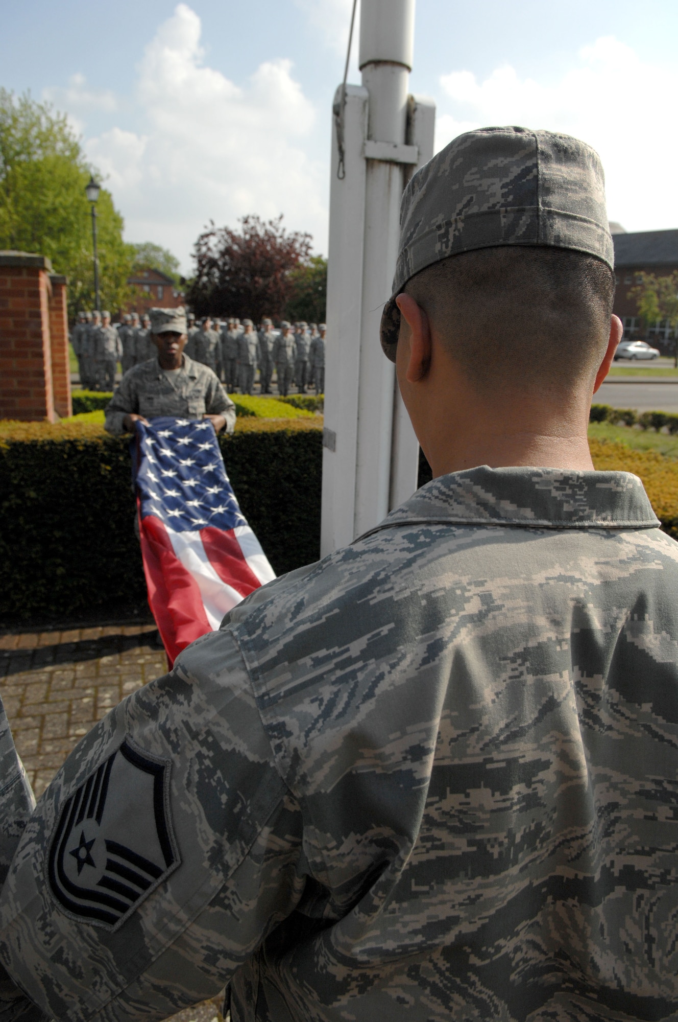 Members of the RAF Mildenhall Honor Guard fold the American flag during a monthly retreat ceremony May 31, 2013, outside of the 100th Air Refueling Wing Headquarters building on RAF Mildenhall, England. Retreat symbolizes the end of the duty day. (U.S. Air Force photo by Airman 1st Class Dillon Johnston/Released)