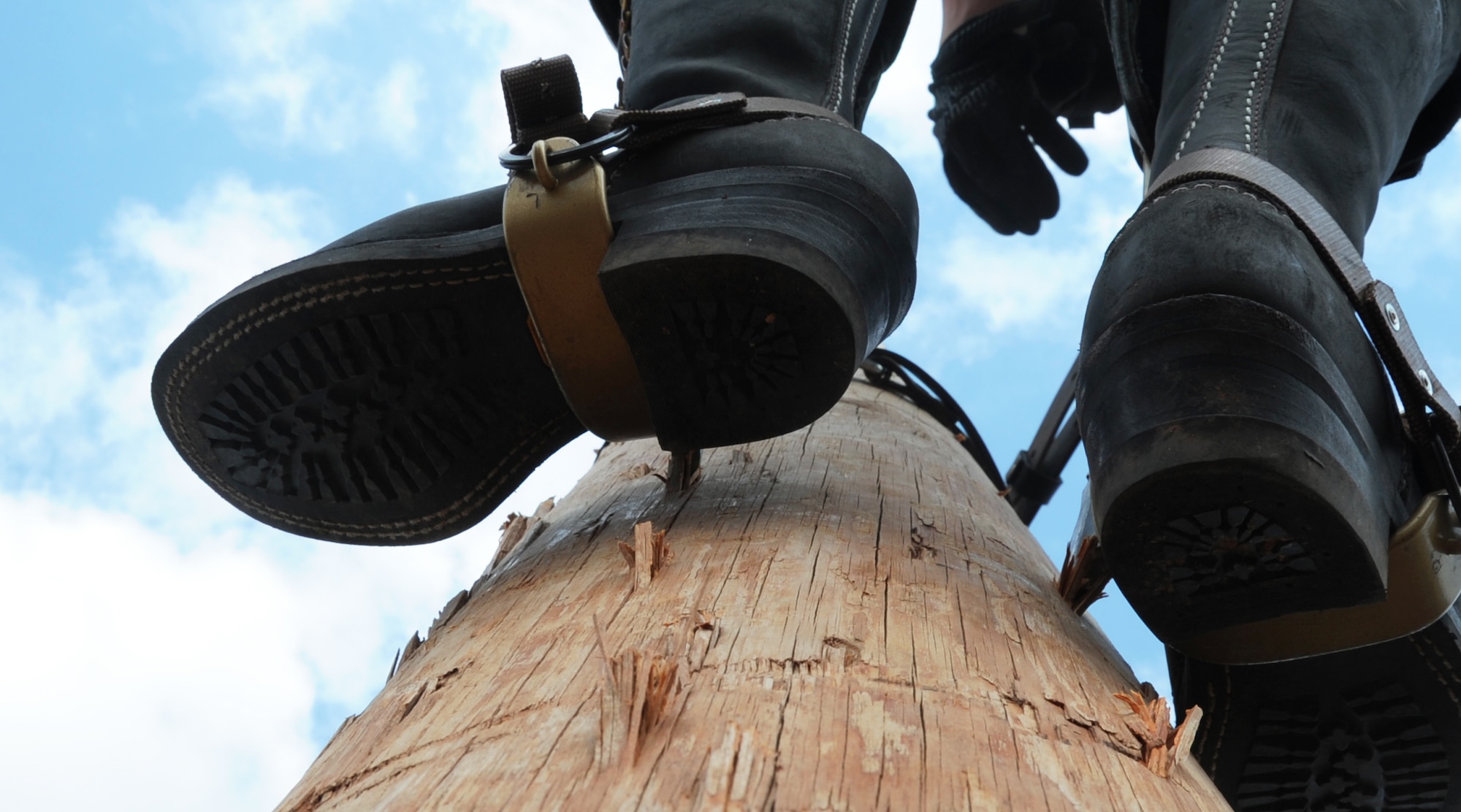ALTUS AIR FORCE BASE, Okla. – Airman 1st Class Randy Moreno, 97th Civil Engineer Squadron electrician, climbs a utility pole in the pole yard, May 30. Electricians use gaffs which are attached to their boots to assists climbing poles. The Electric Shop’s mission is to supply Altus AFB with power by building or repairing power lines and other overhead conductors. They also maintain energy for the fire alarms, lights on the flightline, low voltage interiors, high voltage exteriors and other sources of energy throughout the base.   (U.S. Air Force photo by Airman 1st Class Franklin R. Ramos / Released)