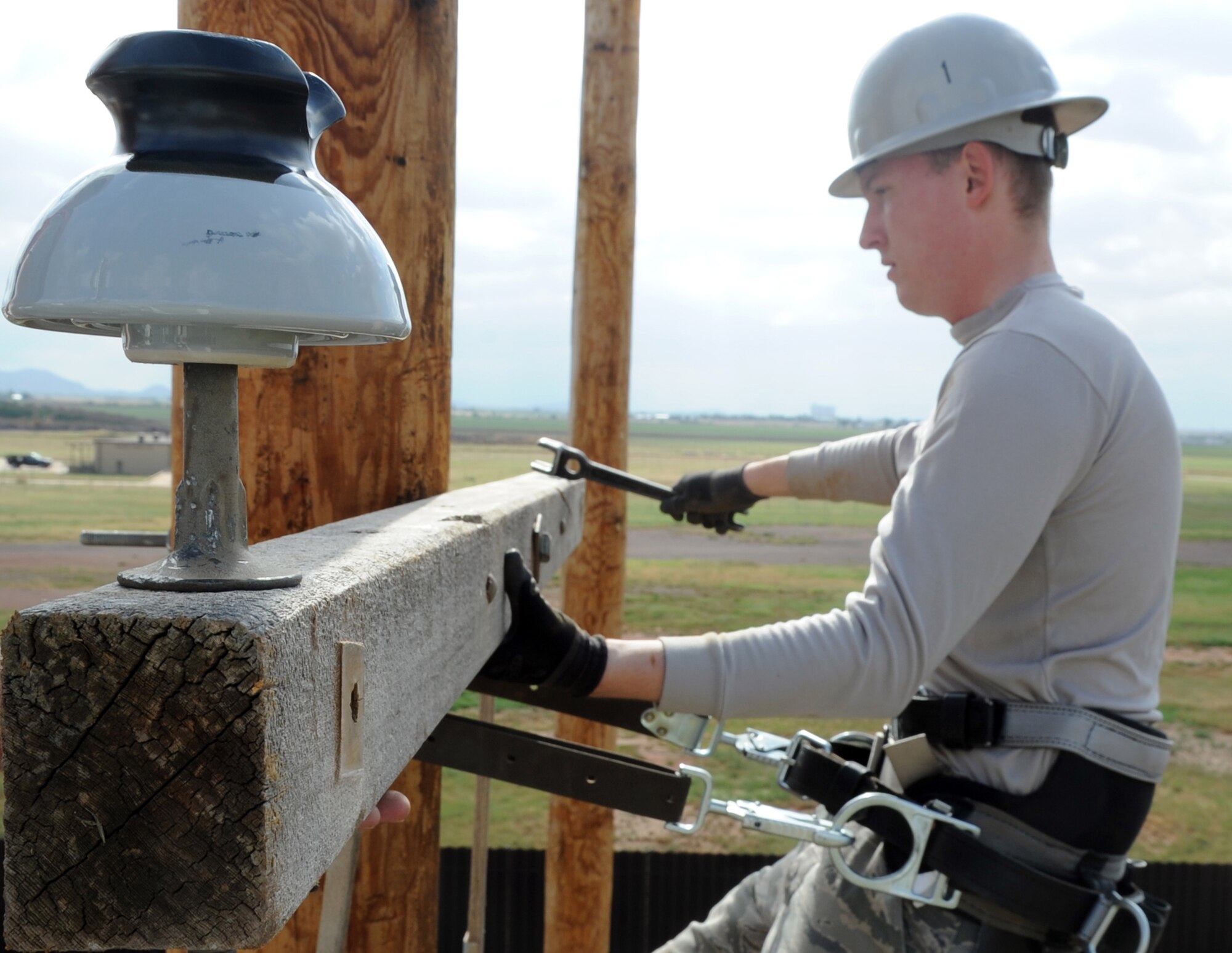 ALTUS AIR FORCE BASE, Okla. – Airman 1st Class Vladimir Purdey, 97th Civil Engineer Squadron electrician, levels a cross arm in the pole yard, May 30. Cross arms are used to support high voltage lines and over head conductors. The Electric Shop’s mission is to supply Altus AFB with power. They also maintain energy for the fire alarms, lights on the flightline, low voltage interiors, high voltage exteriors and other sources of energy throughout the base. (U.S. Air Force photo by Airman 1st Class Franklin R. Ramos / Released)