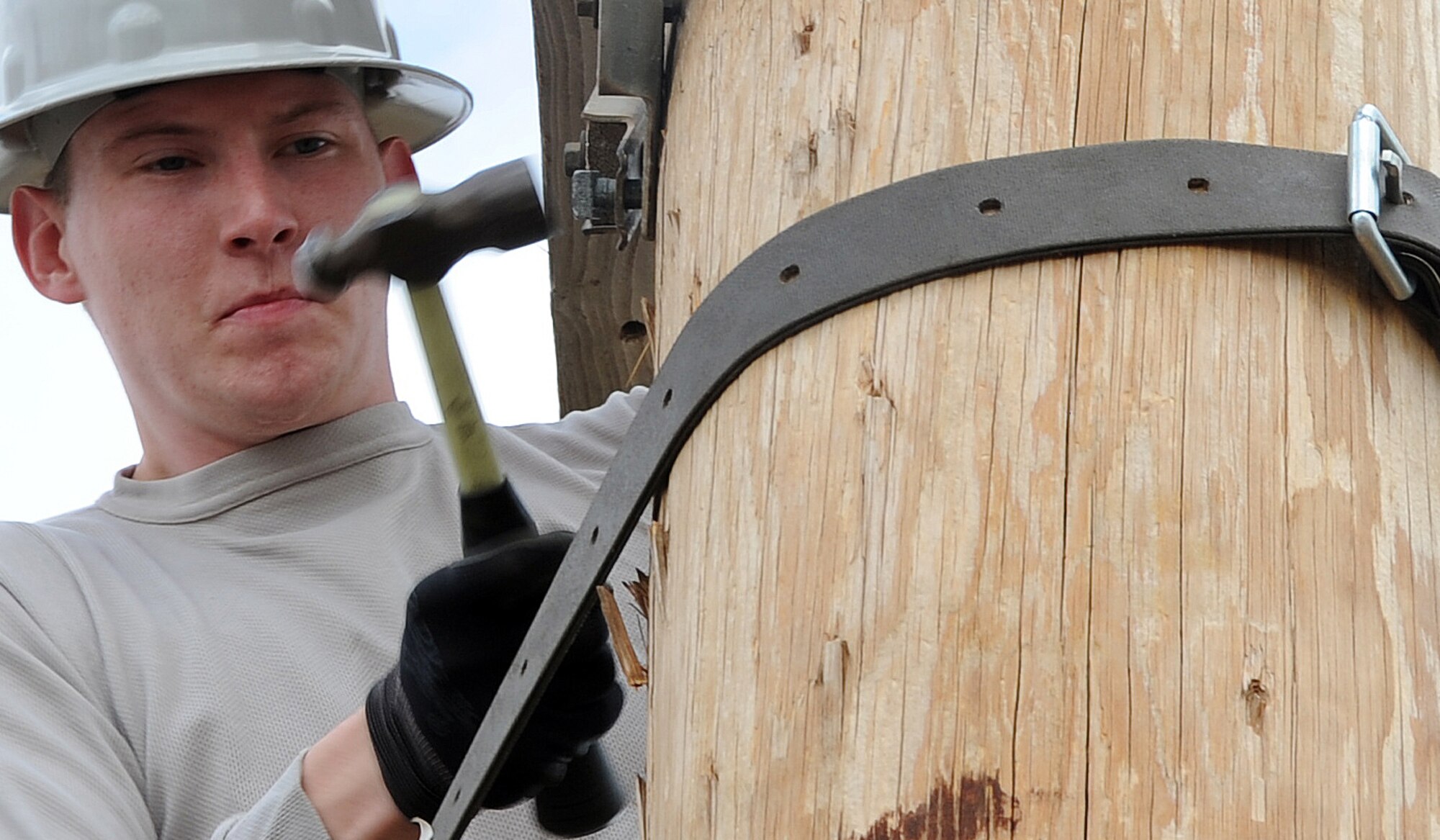 ALTUS AIR FORCE BASE, Okla. – Airman 1st Class Vladimir Purdey, 97th Civil Engineer Squadron electrician, hammers a bolt through a cross arm and into a utility pole in the pole yard, May 30. The bolt was used to help keep the cross arm leveled. The Electric Shop’s mission is to supply Altus AFB with power.  (U.S. Air Force photo by Airman 1st Class Franklin R. Ramos / Released)