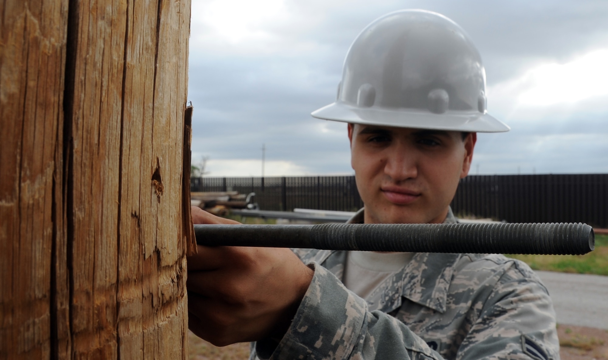 ALTUS AIR FORCE BASE, Okla. – Airman 1st Class Michael Rivera, 97th Civil Engineer Squadron electrician, measures a through-bolt against a utility pole in the pole yard, May 30. Rivera was ensuring that the bolt would be long enough to support a cross arm. The Electric Shop’s mission is to supply Altus AFB with power.  (U.S. Air Force photo by Airman 1st Class Franklin R. Ramos / Released)