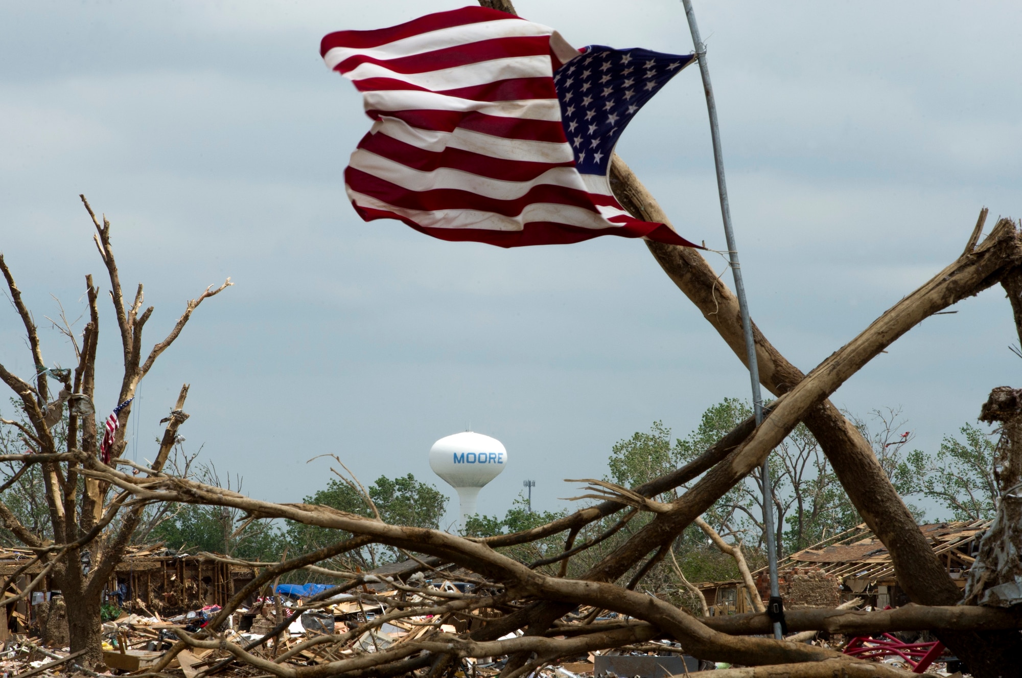 A flag blows in the wind on May 27, over the rubble left in the wake of the May 20 EF-5 tornado that ripped through parts of Moore. (Air Force photo by Tech. Sgt. Bradley C. Church)