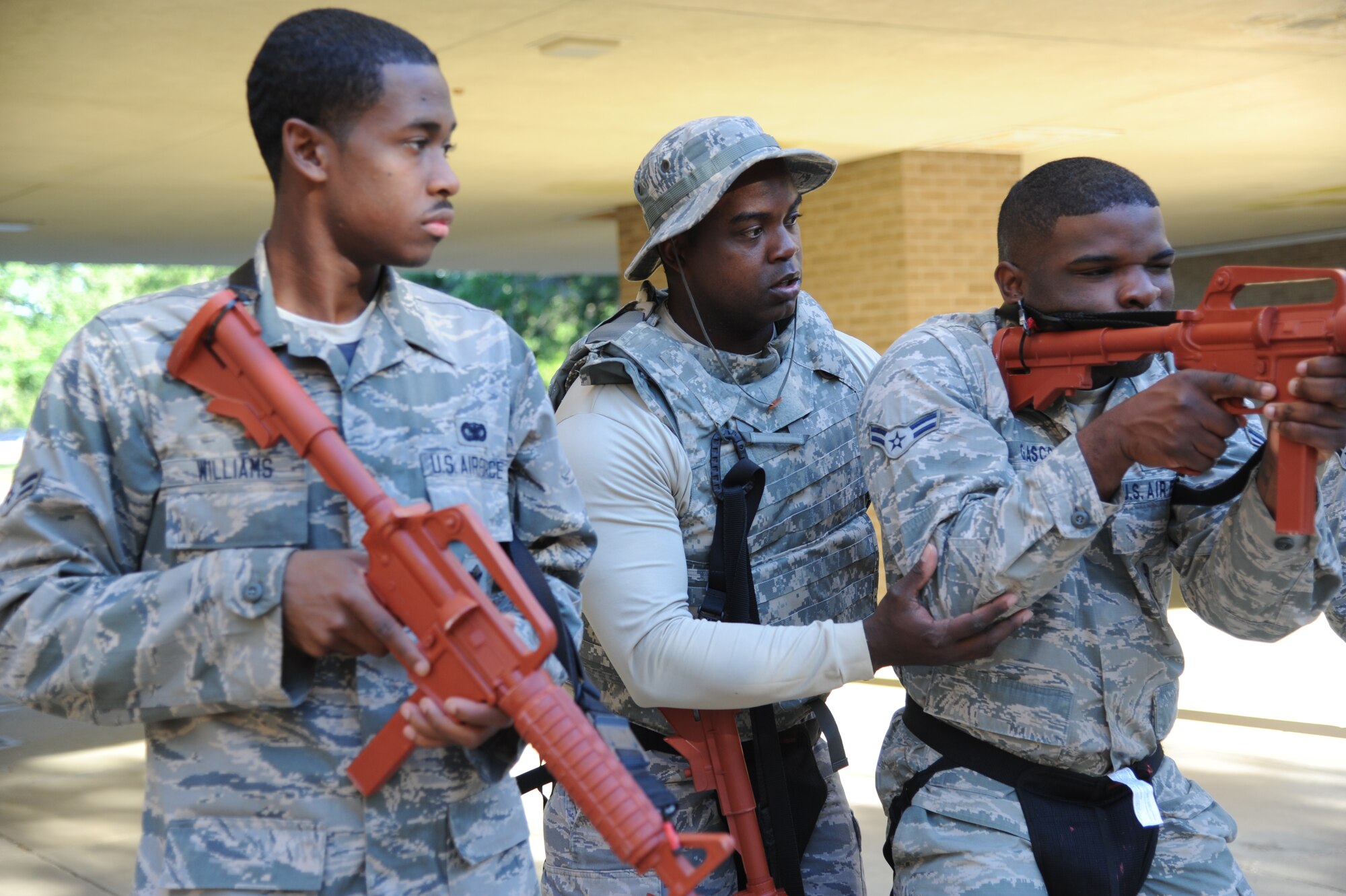 Tech. Sgt. Jason Gavin (center), 81st Security Forces Squadron, assists Airmen 1st Class Matthew Williams and Darryl Glasco, 81st SFS, with the techniques on how to securely and safely hold a simulated weapon during active shooter training May 28, 2013, at The Locker House, Keesler Air Force Base, Miss.  The two-day annual training helps to prepare them to react during real-world situations.  (U.S. Air Force photo by Kemberly Groue)