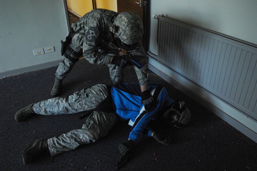 Chief Master Sgt. Tracy Jones, 100th Air Refueling Wing command chief, checks a downed shooter during use of force and active shooter training May 31, 2013, at RAF Mildenhall, England. Jones practiced several scenarios which tested his ability to determine what level of force was to be used. (U.S. Air Force photo by Airman 1st Class Dillon Johnston/Released)