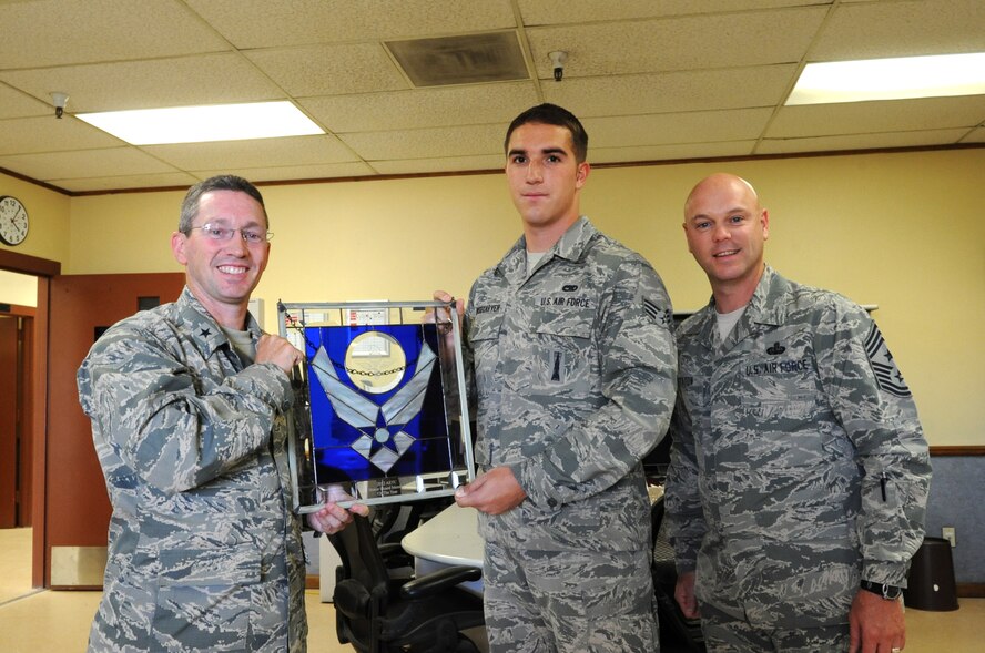 Brig. Gen. Mike Rothstein, 56th Fighter Wing commander, and Chief Master Sgt. David Staton, 56th FW command chief, present Senior Airman Kyle Wisecarver, 756th Aircraft Maintenance Squadron weapons load crew member, with the 2012 Air Education and Training Command Honor Guard Member award May 21 at Luke Air Force Base. During his time as an honor guard member, Wisecarver performed in more than 170 ceremonies and led a six-member team during 23 events including retirement, flag and change-of-command ceremonies. (U.S. Air Force photo/Staff Sgt. Nestor Cruz)