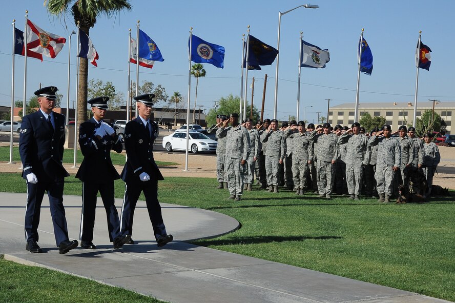 Members of the 56th Security Forces Squadron salute as members of the Luke Honor Guard perform retreat during the S.S. Mayaguez Memorial Retreat Ceremony. The ceremony is held annually to remember security forces members who gave their lives in the line of duty. (U.S. Air Force photo/Airman 1st Class James Hensley)