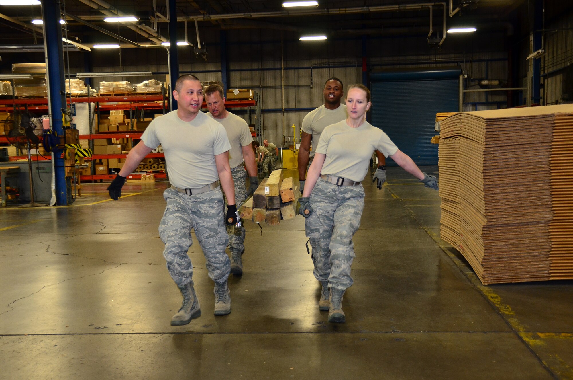 WRIGHT-PATTERSON AIR FORCE BASE, Ohio - Two teams race against the clock to complete the 87th Aerial Port Squadron team building challenge that included push-ups, carrying a litter of planks followed by executing 25 jumping jacks, then exchanging the planks for an egg before crossing the finish line without dropping it. The challenge was part of the 445th Airlift Wing annual Wingman Day held during the April 21 unit training assembly. (U.S. Air Force photo/Staff Sgt. Amanda Duncan)