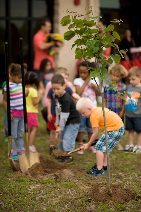 Children from the Hurlburt Field Child Development Center East help during a tree planting ceremony at the CDC East at Hurlburt Field, Fla., April 24, 2013.  Tree planting helps minimize erosion, provides wind breaks and cuts cooling and heating costs. (U.S. Air Force Photo/Senior Airman Hayden K. Hyatt)