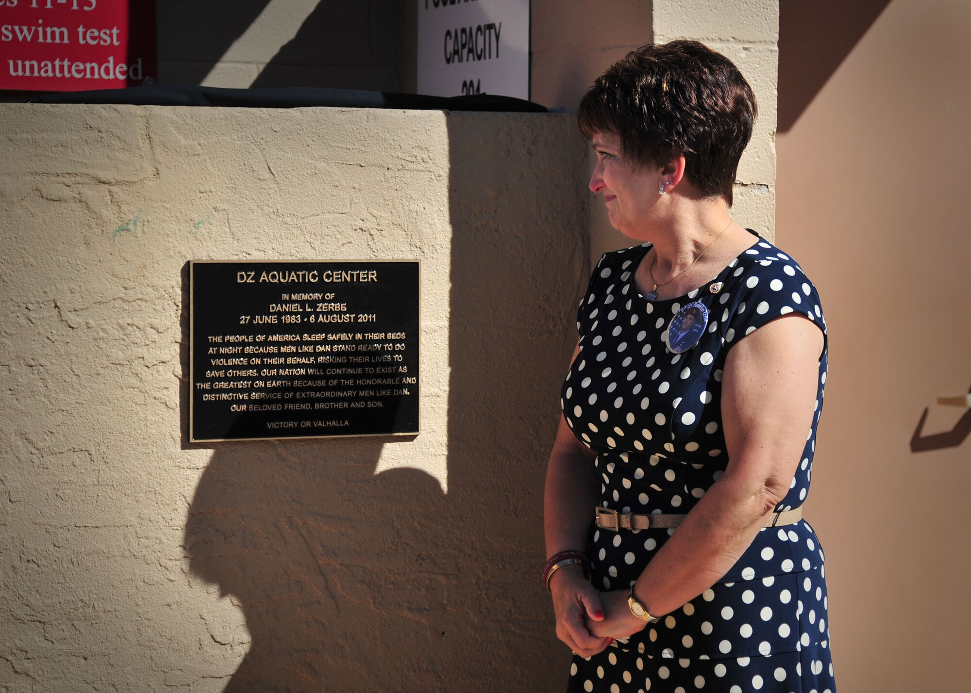 Susan Zerbe, mother of U.S. Air Force Tech. Sgt. Daniel L. Zerbe, unveils the memorization plaque for her son at the base pool at Cannon Air Force Base, N.M., May 27, 2013. The DZ Pool was named in remembrance of Zerbe, a pararescueman who formally served under Air Force Special Operations Command and perished in the line of duty. (U.S. Air Force photo/Senior Airman Alexxis Pons Abascal) 