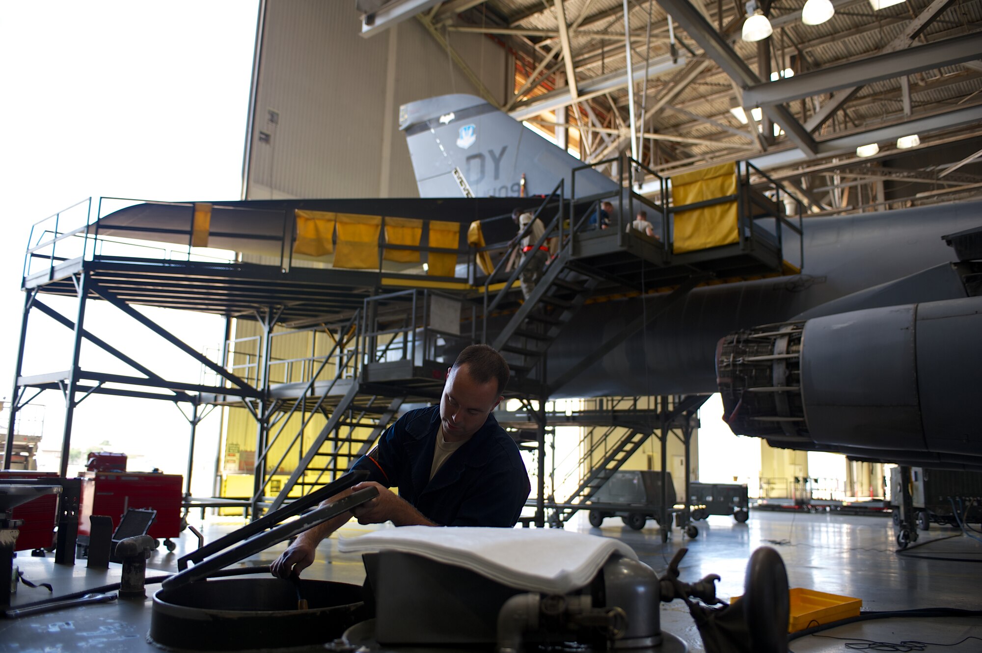 U.S. Air Force Staff Sgt. Mathew Johnson, 7th Equipment Maintenance Squadron, places a hose into a hydraulic fluid holding tank while servicing a B-1 Bomber May 16, 2013, at Dyess Air Force Base, Texas. While being serviced, more than 215 panels are removed and every component of the aircraft is inspected. (U.S. Air Force photo by Tech. Sgt. Joshua T Jasper/Released)