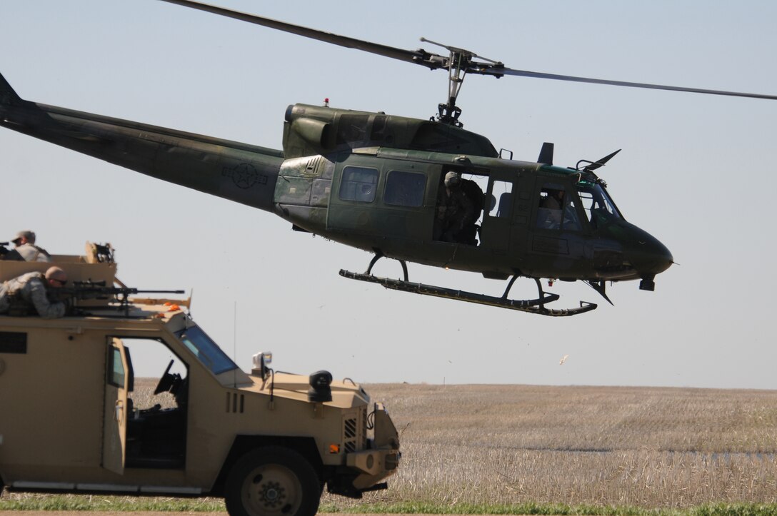 A U.S. Air Force UH-1N helicopter, of the 54th Helicopter Squadron, leads members of the 91st Missile Security Forces Squadron and the 219th Security Forces Squadron as they advance to prevent a simulated assault on a missile launch facility during an intense but routine exercise May 22, 2013, in the Minot Air Force Base missile field complex near Minot, N.D. The exercise is significant because it is a final step in the complete integration of the U.S. Air Force active-duty forces of the 91st Missile Security Forces Group and the Air National Guard’s 219th Security Forces Squadron. The missile field complex covers 8,500 square miles in North Dakota, and the Air National Guard members are interchangeable with the active-duty personnel in the security mission throughout the complex.