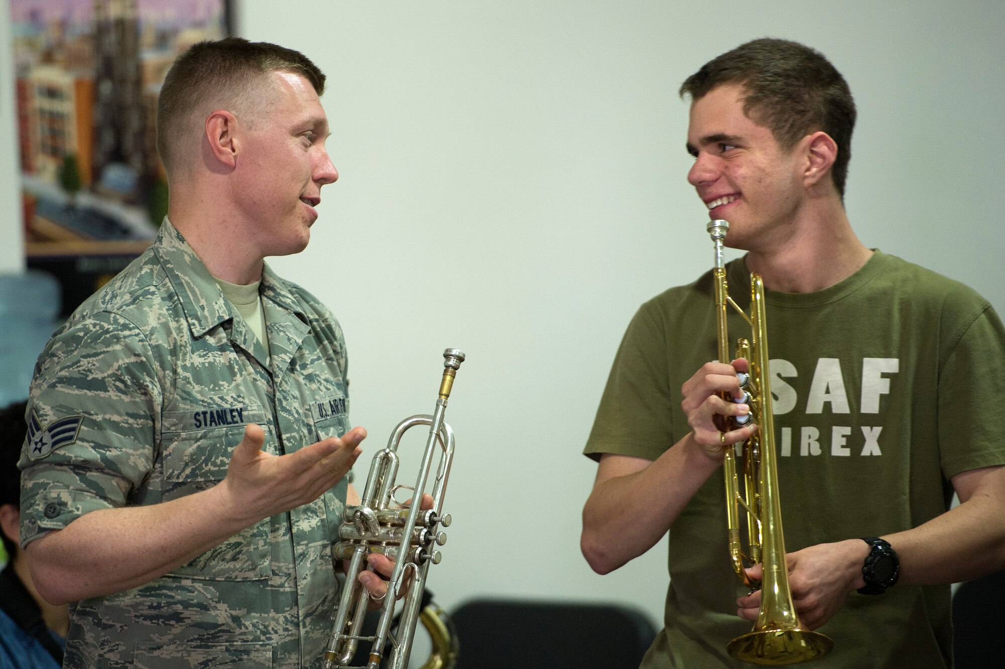 Senior Airman Carl Stanley, AFCENT Band trumpet player, mentors a fellow horn player at the American School of Doha May 30, 2013. Stanley, along with two other brass instrumentalists, conducted a masters class with students in their final weeks of school.  ASD is attended by students from more than 80 nations. (USAF Photo by Master Sgt. Ben Bloker)