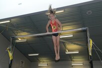 Gracie Willis practices on the uneven parallel bars May 16 at the Joint Base San Antonio-Randolph Youth Center. (U.S. Air Force photo by Joel Martinez/ Released)