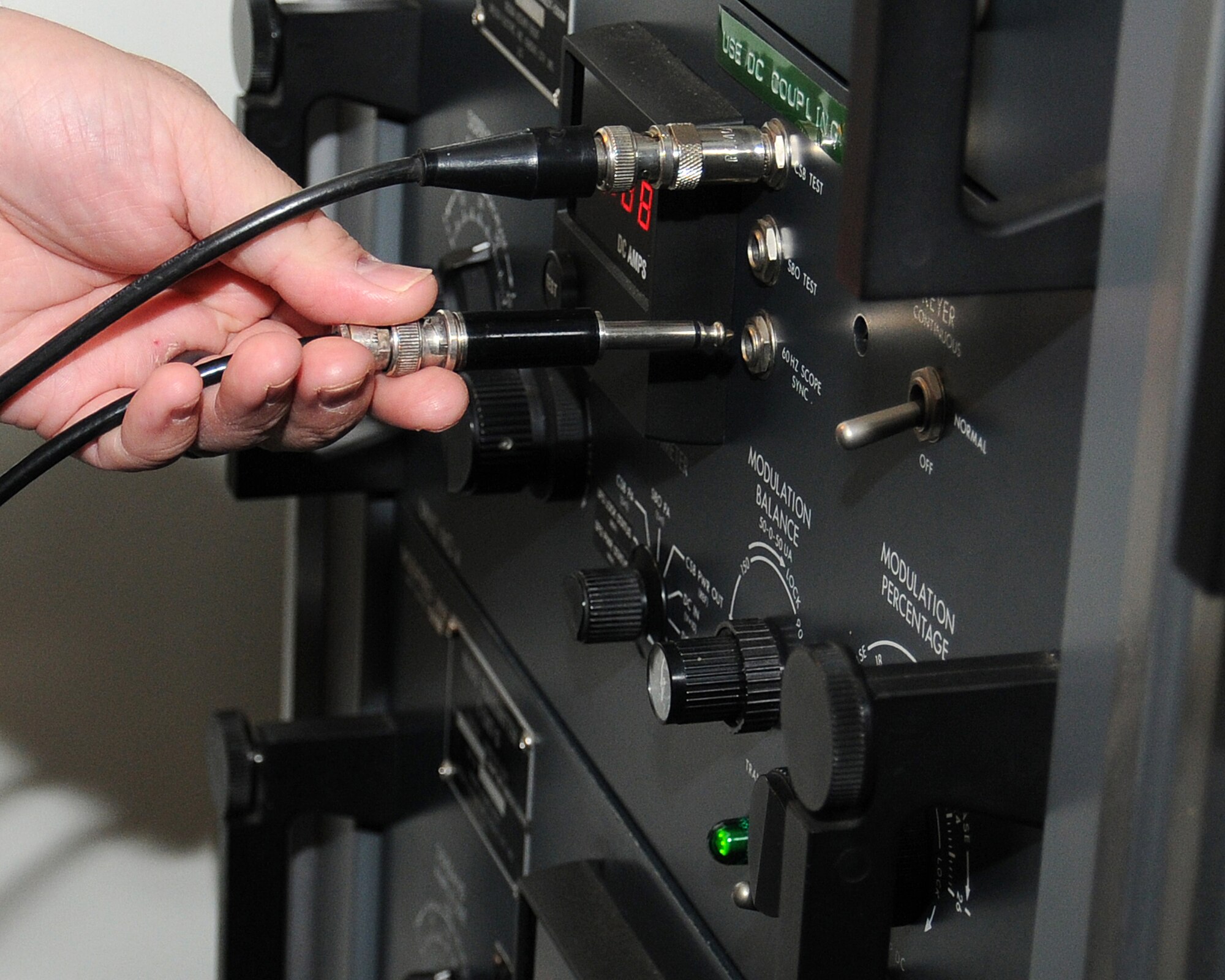 John Hopson, 100th Communications Squadron Airfield Systems technician from Kings Lynn, Norfolk, plugs in an audio cable to view the audio signal of the navigational landing system May 24, 2013, on RAF Mildenhall, England. Hopson is part of the airfield systems shop, which maintains the air traffic control radios and navigational landing systems at both RAF Mildenhall and RAF Fairford. (U.S. Air Force photo by Gina Randall/Released)