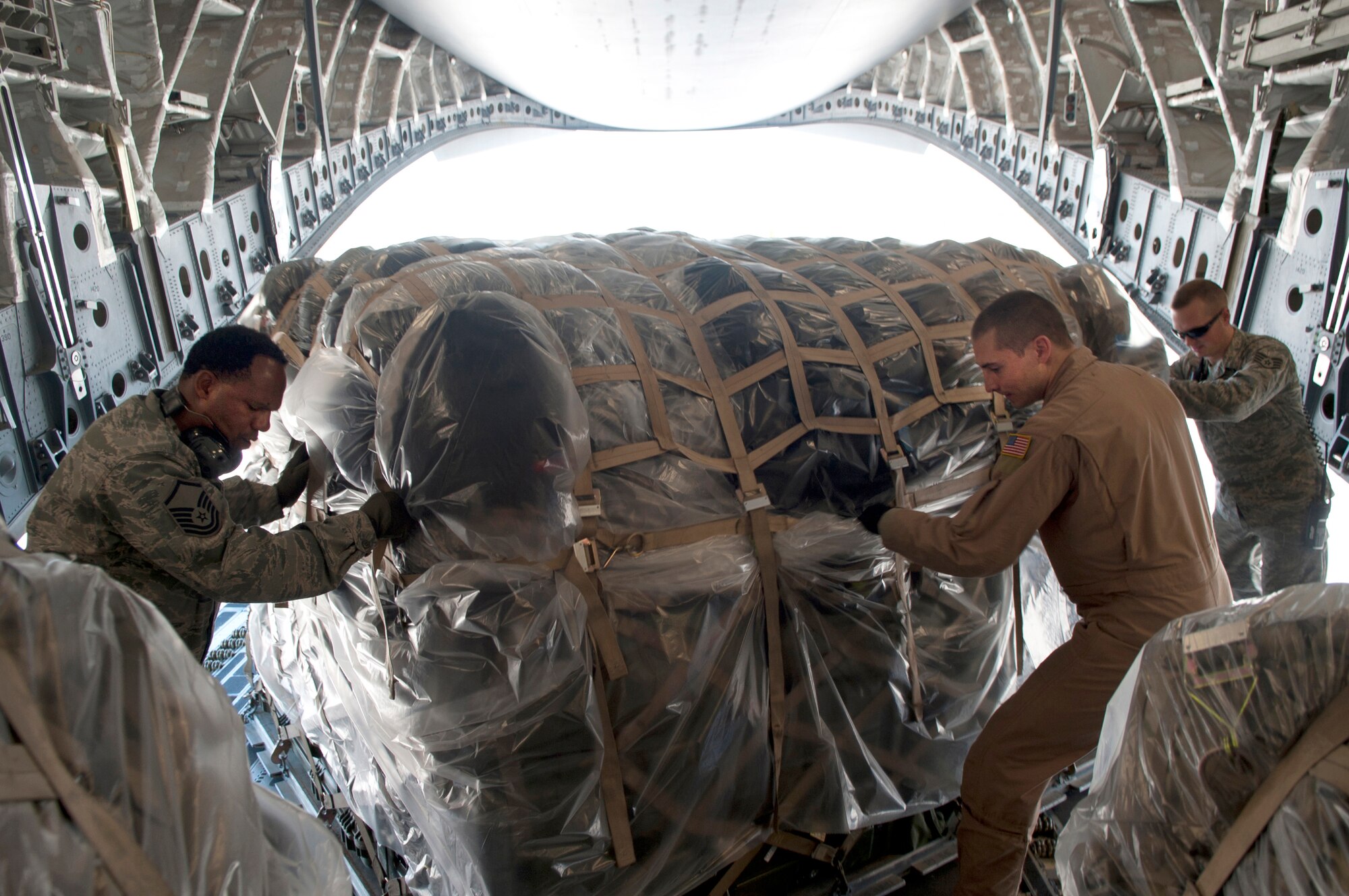 Members of the 376th Expeditionary Logistics Readiness Squadron Air Terminal Operations Center help a loadmaster rotate a cargo pallet to be secured with other loads in the C-17 Globemaster III at Transit Center at Manas, Kyrgyzstan, May 27, 2013. ATOC’s overall mission supporting air refueling, airlift and onward movement. (U.S. Air Force photo/Staff Sgt. Robert Barnett)