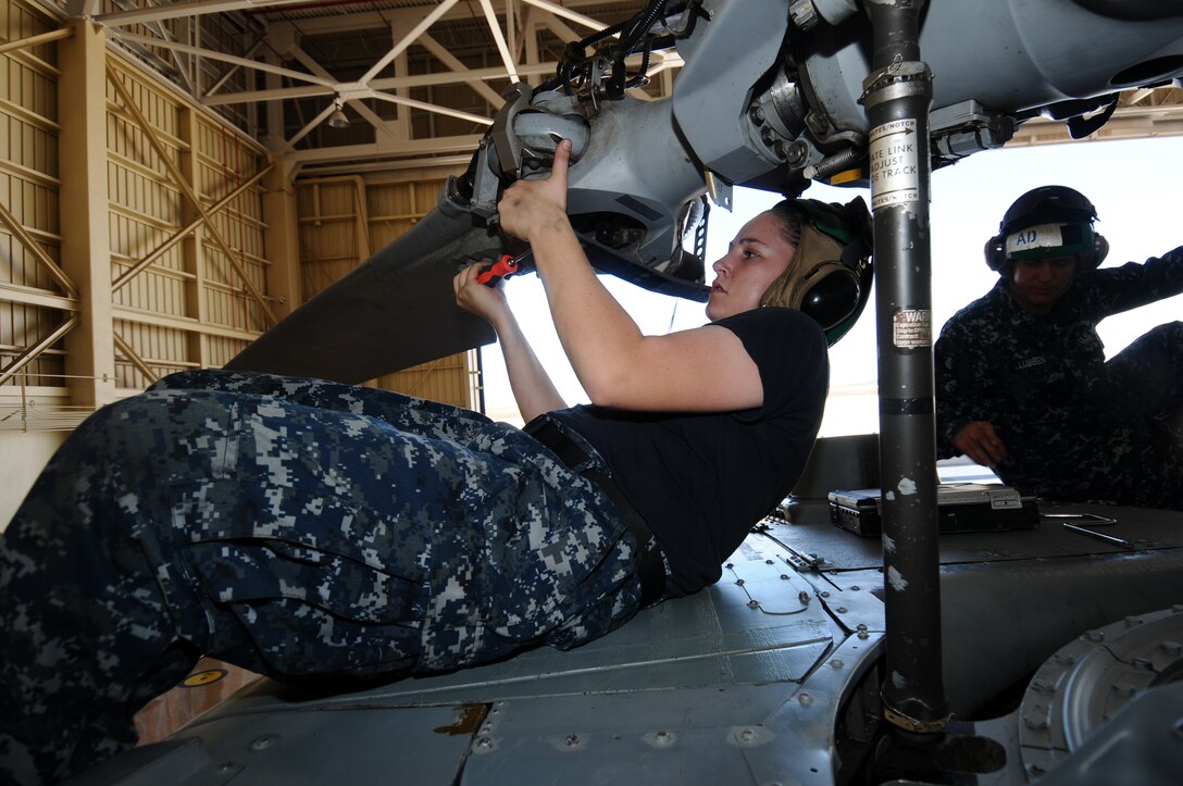 Airman Eleanor Poile, Helicopter Sea Combat Squadron 25 aviation machinist’s mate, focuses on repairing a rotar May 30, 2013, on Andersen Air Force Base, Guam. Currently, HSC-25 has two maintenance shifts to provide around-the-clock support for search and rescue missions, firefighting and medical evacuations along with a multitude of other military operations. (U.S. Air Force photo by Airman 1st Class Emily A. Bradley/Released)