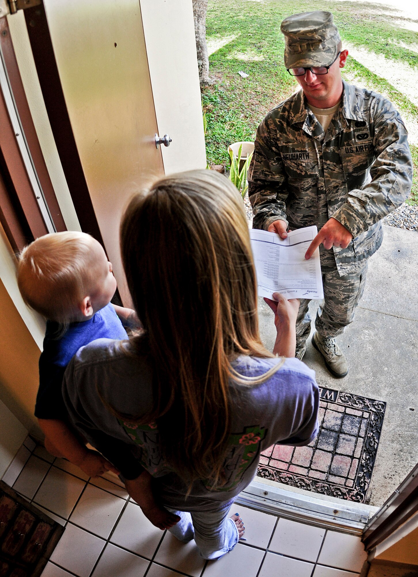 Airman 1st Class Taylor Neuharth, 36th Civil Engineer Squadron emergency management apprentice, explains the base’s disaster preparedness plan to military family housing residents May 30, 2013, on Andersen Air Force Base, Guam. The emergency management flight’s mission is to lead base preparation, response and recovery from all types of hazards, disasters and catastrophes. (U.S. Air Force photo by Airman 1st Class Marianique Santos/Released)