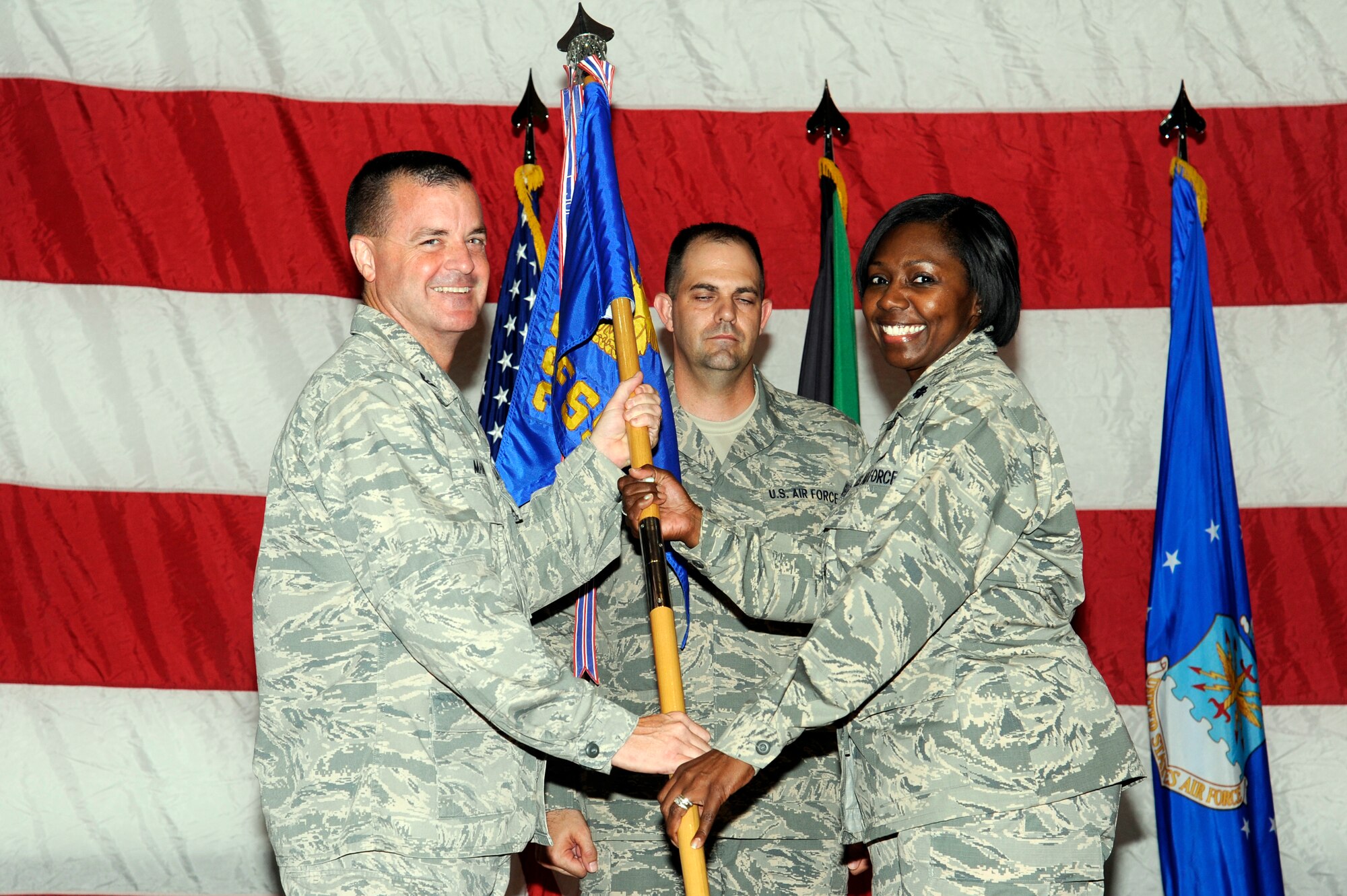 Col. Joseph Martin, 386th Expeditionary Mission Support Group commander, left, passes the 386th Expeditionary Force Support Squadron guidon to Lt. Col. Cotina Jenkins-Sellers during a change of command ceremony May 30 at an undisclosed location in Southwest Asia. Lt. Col. Jenkins-Sellers assumed command of the 386th EFSS from Lt. Col. Carolyn Ammons. (U.S. Air Force photo by Staff Sgt. Austin Knox)