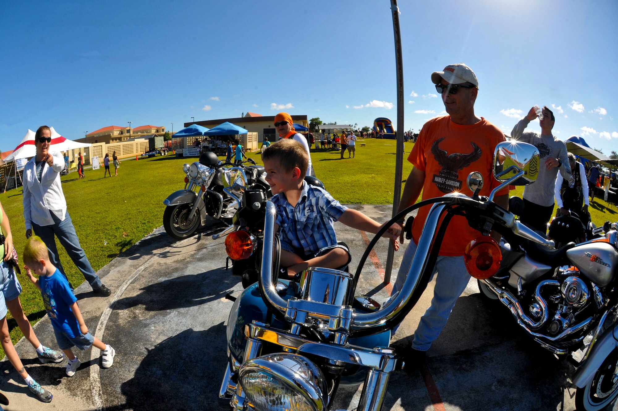 A child sits on top of a motorcycle as members of the Harley Owners of Guam motorcycle club talk about motorcycle safety during the Memorial Day Bash May 24, 2013, on Andersen Air Force Base, Guam. The club allowed children and Airmen to pose for pictures on their motorcycles as they briefed the importance of riding safe, tips for navigating Guam’s roads and other motorcycle safety information. (U.S. Air Force photo by Senior Airman Robert Hicks/Released)