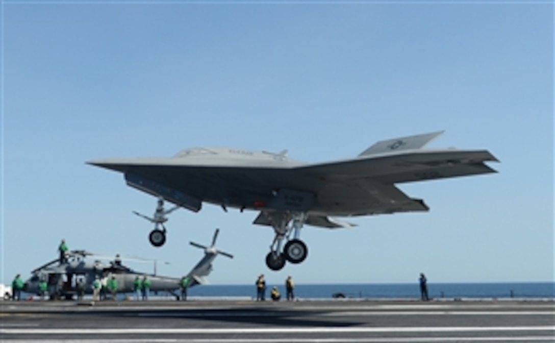 A Navy X-47B Unmanned Combat Air System demonstrator aircraft prepares to execute a touch and go landing on the flight deck of the aircraft carrier USS George H.W. Bush (CVN 77) as the ship conducts flight operations in the Atlantic Ocean on May 17, 2013.  This marks the first time any unmanned aircraft has completed a touch and go maneuver at sea.  