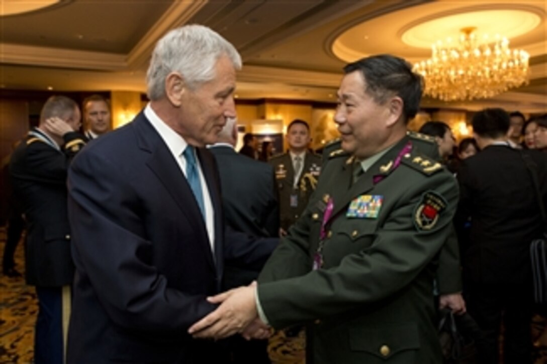 Secretary of Defense Chuck Hagel, left, greets Deputy Chief of General Staff for the People's Liberation Army Gen. Qi Jianguo at the start of the Shangri-La Dialogue in Singapore, on May 31, 2013.  Hagel told Qi that President Obama is looking forward to hosting Chinese President Xi in California to discuss areas of mutual concern.  