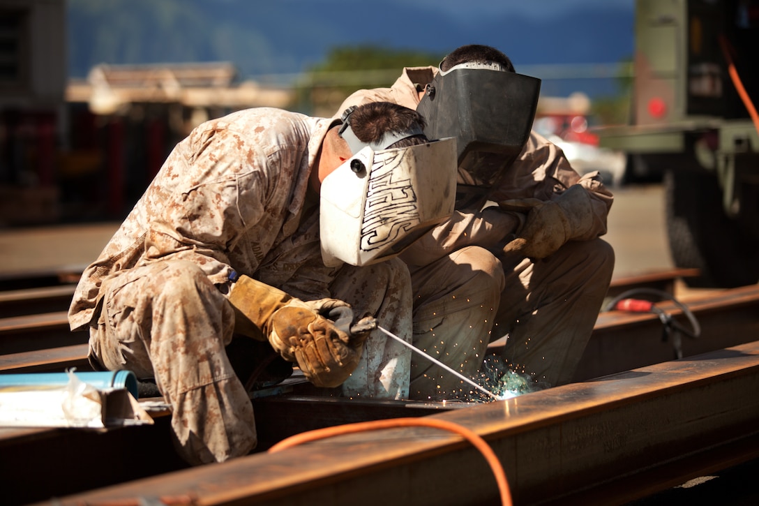 MARINE CORPS BASE HAWAII — Cpl. Raymond Adams (left), a metal worker with Combat Logistics Battalion 3 and 25-year-old native of Donalsonville, Ga., and Sgt. Mark Cureo, a metal worker with CLB-3 and 24-year-old native of Sacramento, Calif., stick weld I-beams together at engineer building lot 4079, Oct. 24, 2013. (U.S. Marine Corps photo by Lance Cpl. Nathan Knapke)