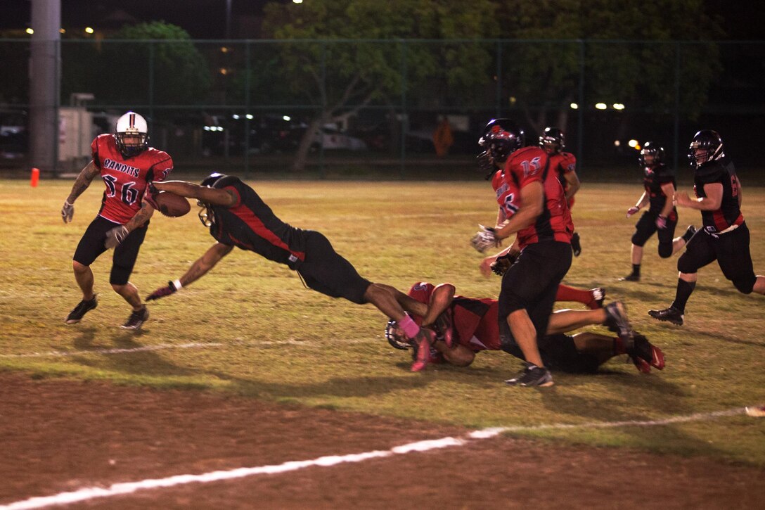 Jauvaurion McCray, a running back for the 1st Battalion, 12th Marine Regiment Savages, stretches out to advance the football during a football game at Riseley Field, Oct. 29, 2013.(U.S. Marine Corps photo by Lance Cpl. Nathan Knapke) 