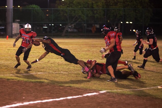 Jauvaurion McCray, a running back for the 1st Battalion, 12th Marine Regiment Savages, stretches out to advance the football during a football game at Riseley Field, Oct. 29, 2013.(U.S. Marine Corps photo by Lance Cpl. Nathan Knapke) 