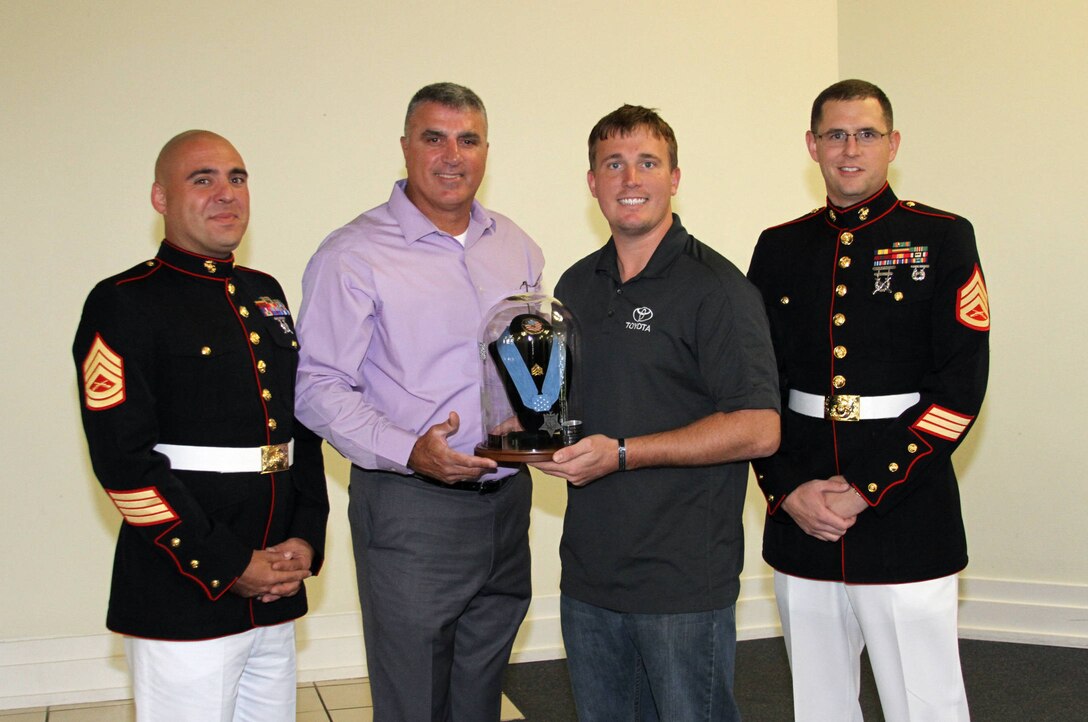 The Medal of Honor Tribute was presented to Dakota Meyer (right center) at Lindsey Wilson College Oct. 28, 2013. Richard Powers (left center), creator of the tribute and retired sergeant first class, along with Gunnery Sgt. Allen Rosenblatt (left), staff non-commissioned officer-in-charge of Recruiting Sub-station Elizabethtown, and Staff Sgt. John Allison (right), RSS Elizabethtown recruiter, assisted Powers in presenting the tribute to Meyer.  (U.S. Marine Corps photo by Sgt. Daniel Angel/Released)