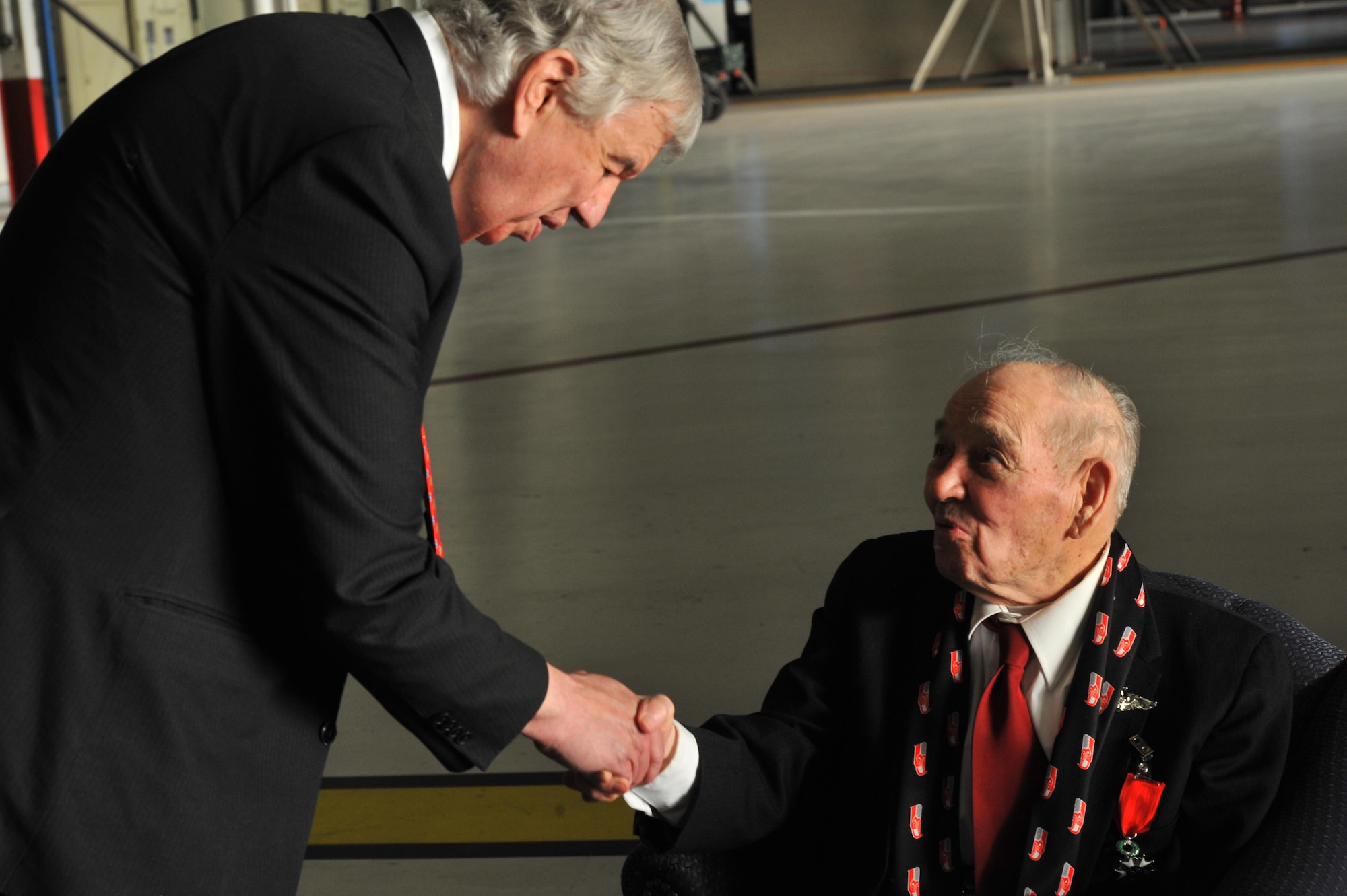 Jack Cowan of Honorary Consul of France shakes hands with retired Maj. Clarence Grimes Oct. 25, 2013, at Fairchild Air Force Base, Wash. The 92-year old was honored with the highest recognition by the French government for his contributions almost 70 years ago to defend and preserve the independence of France.