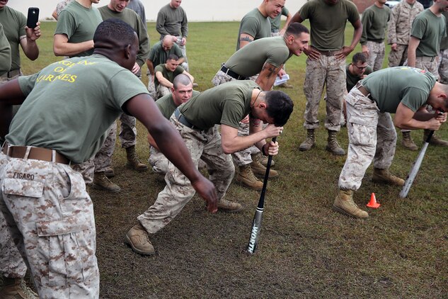 Marines with 2nd Maintenance Battalion, Combat Logistics Regiment 25, 2nd Marine Logistics Group perform the ‘dizzy izzy’ during a field meet at the 2nd Maint. Bn. compound aboard Camp Lejeune, N.C., Oct. 31, 2013. Marines had to keep their forheads placed on the bat and spin around 10 times in each direction, then race each other.
