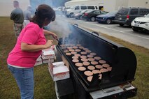 A volunteer with the 2nd Maintenance Battalion family readiness program grills hamburgers during a field meet at the battalion’s compound aboard Camp Lejeune, N.C., Oct. 31, 2013. The battalion hosted a field meet challenging Marines with a series of physical obstacles. 