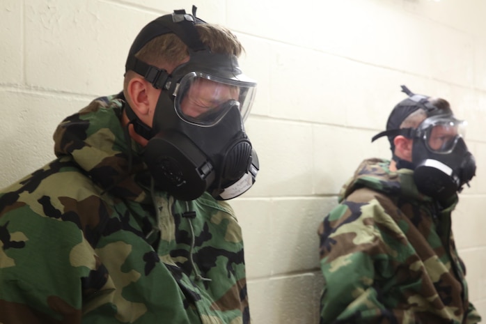 A service member with 2nd Supply Battalion, Combat Logistics Regiment, 2nd Marine Logistics Group reacts to the burning sensation caused by 2-chlorobenzalmalonoitrile, or CS gas, after clearing his M50 Joint Service General Purpose Mask aboard Camp Lejeune, N.C., Oct. 31, 2013. The burn allows service members to build confidence that their equipment works and that they know how to use it properly.