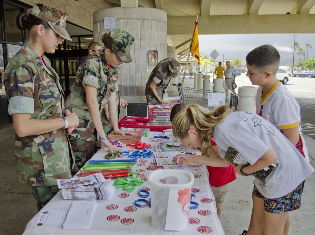 The Pyramid Rock Young Marines encourage military family members to sign pledges to be drug-free at the Marine Corps Base Hawaii commissary, Oct. 27, 2013. The Pyramid Rock Young Marines held a drive for recruitment and collecting canned goods while handing out information about Red Ribbon Week. (U.S. Marine Corps photo by Kristen Wong)